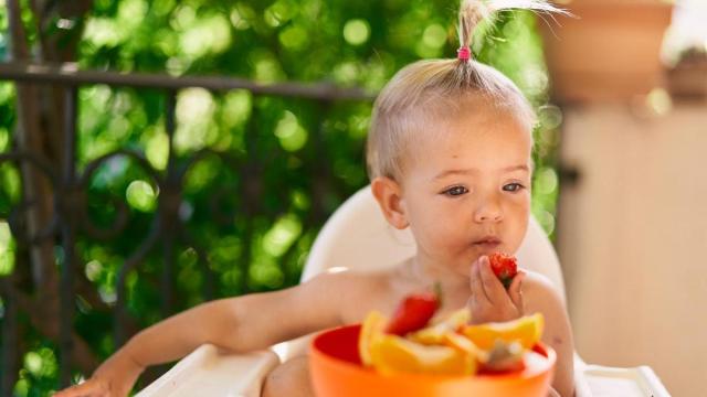 Niña come fruta en verano.