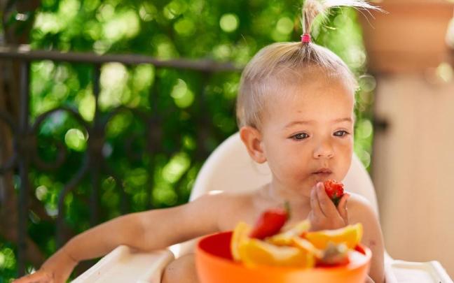 Niña come fruta en verano.