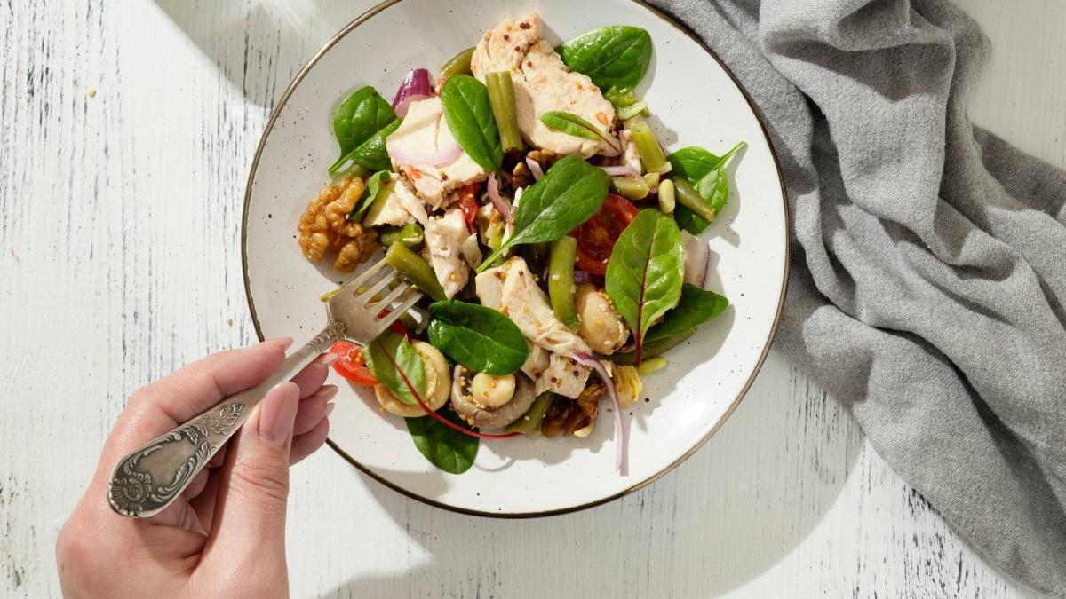 Ensalada con pechuga de pollo, frutos secos y verduras.