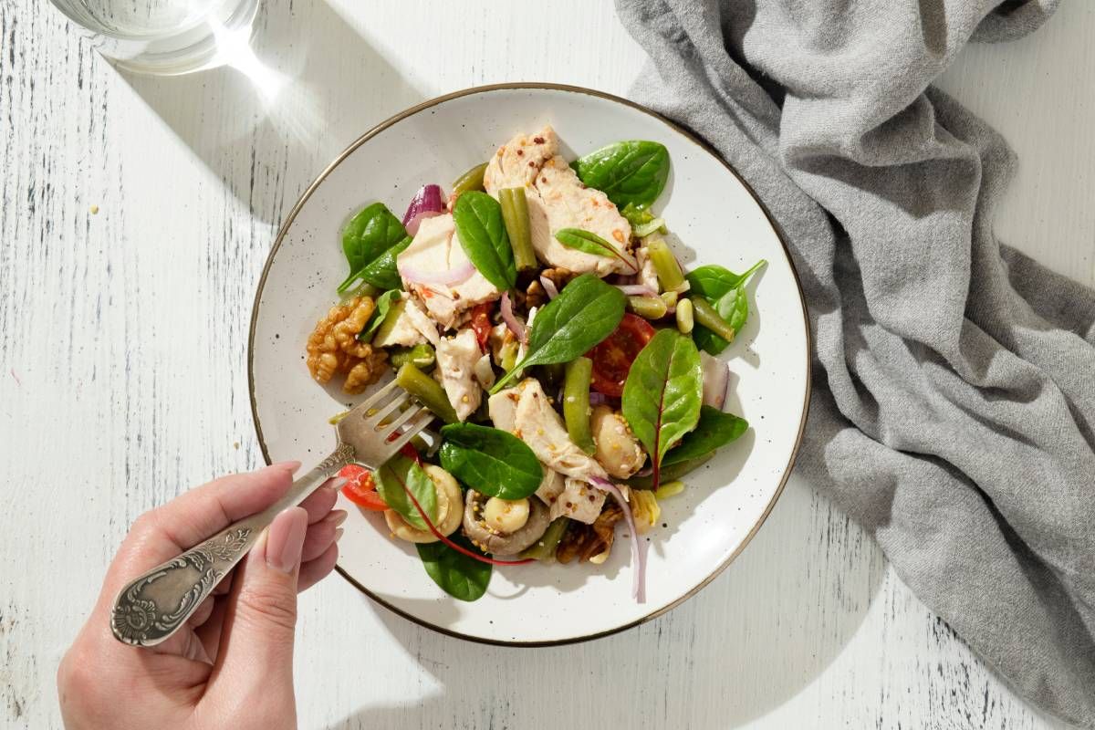 Ensalada con pechuga de pollo, frutos secos y verduras.