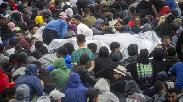 Agentes de la Policía Nacional intervienen durante el proceso de desalojo del embolsamiento de migrantes en la playa de El Trampolín.