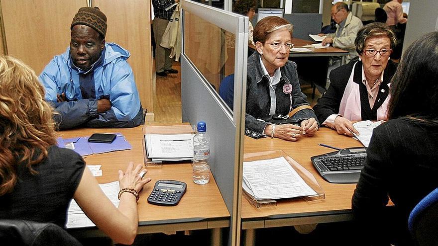 Varias personas, realizando la declaración de la renta. | FOTO: EFE