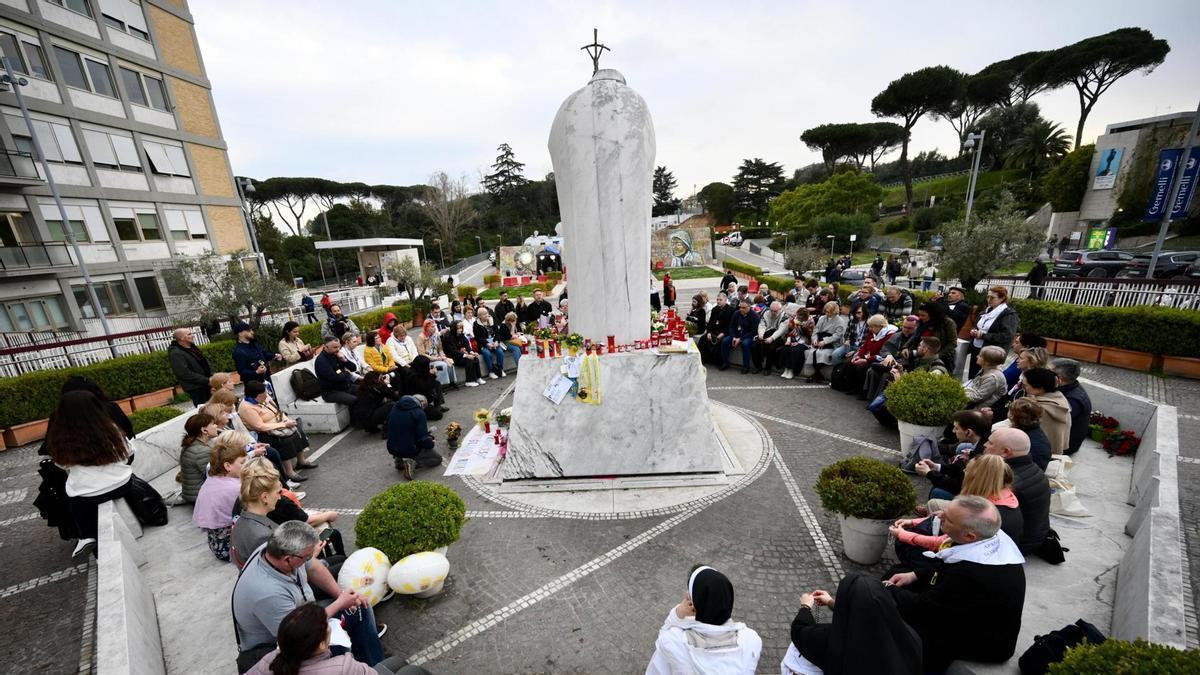 Los fieles se concentran ante la estatua de Juan Pablo II en el hospital Gemelli de Roma.