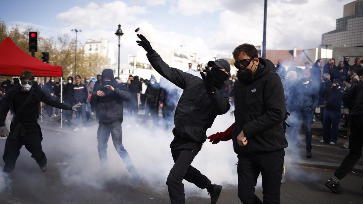 Un manifestante lanza una lata de gas lacrimógeno durante una protesta en París.