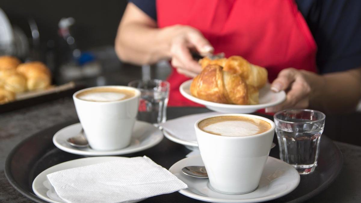 Una camarera sirve un desayuno en una cafetería.
