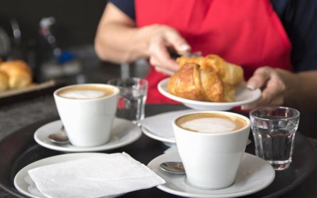 Una camarera sirve un desayuno en una cafetería.