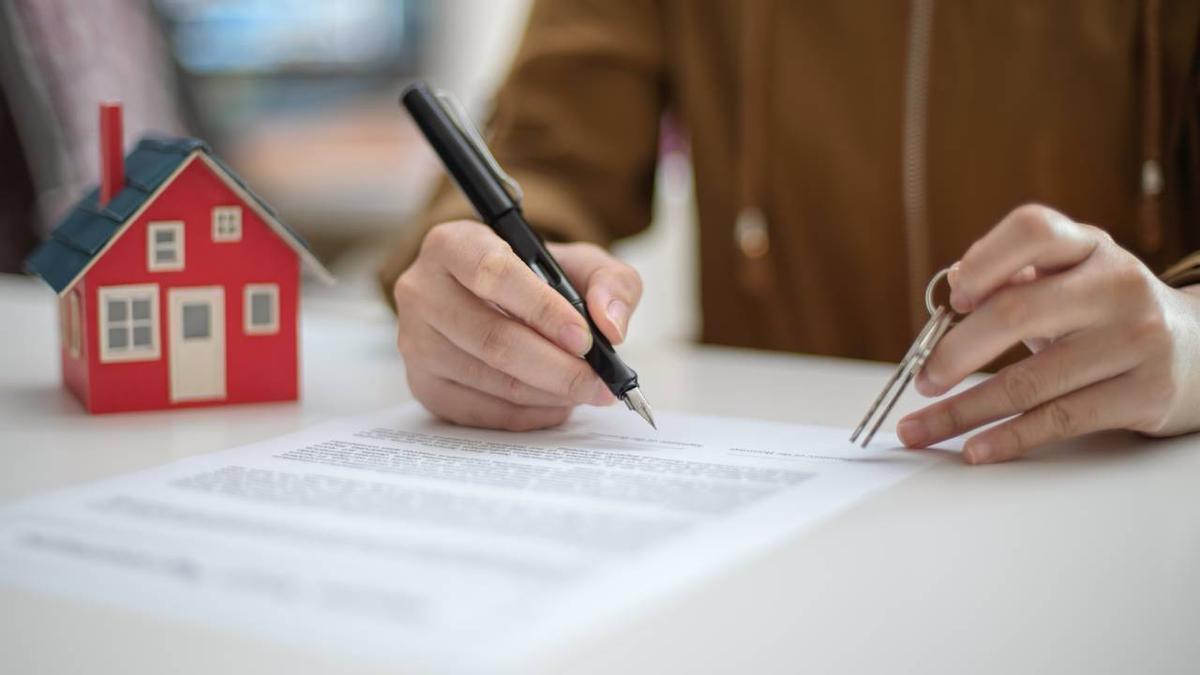 Una mujer firma un acuerdo de préstamo hipotecario