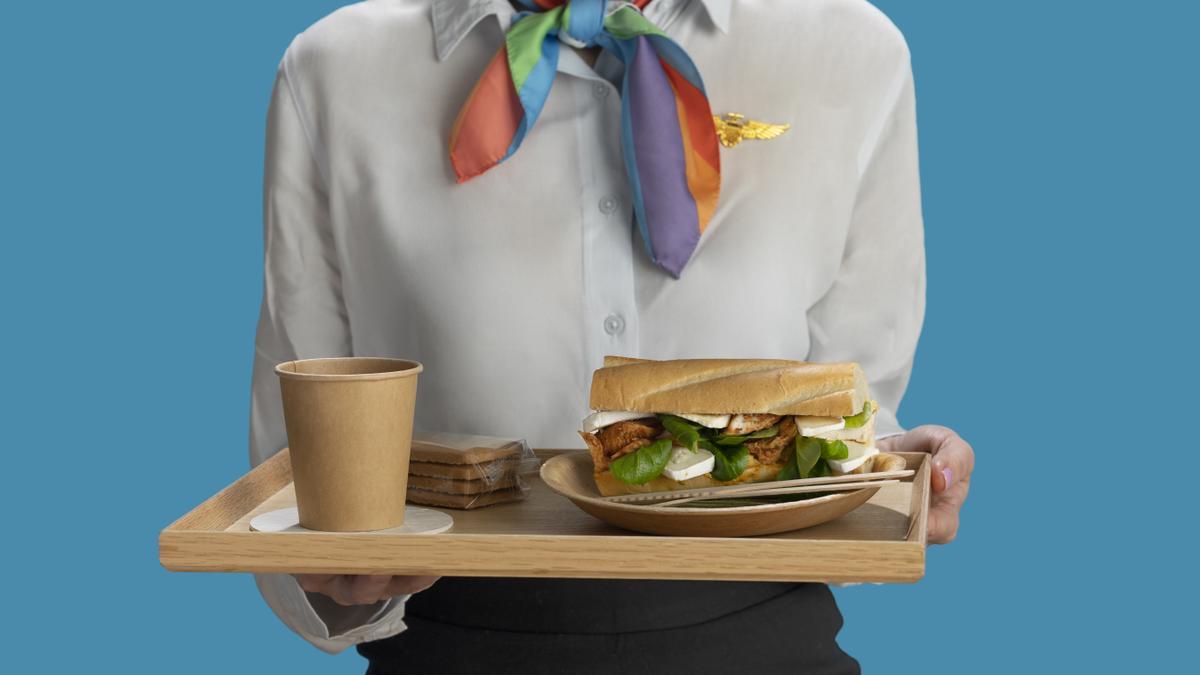 Azafata lleva comida en una bandeja.