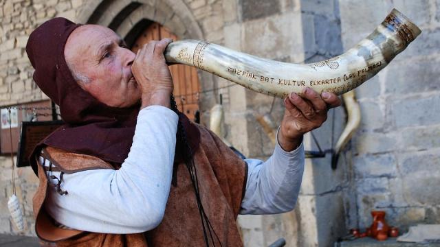 El maestro artesano Juan Antonio Alaña anunciando la apertura del mercado de antaño de Artziniega con una de sus creaciones en cuerno