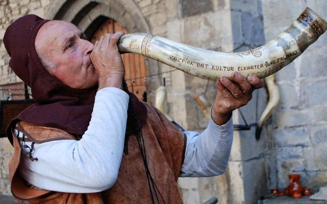 El maestro artesano Juan Antonio Alaña anunciando la apertura del mercado de antaño de Artziniega con una de sus creaciones en cuerno