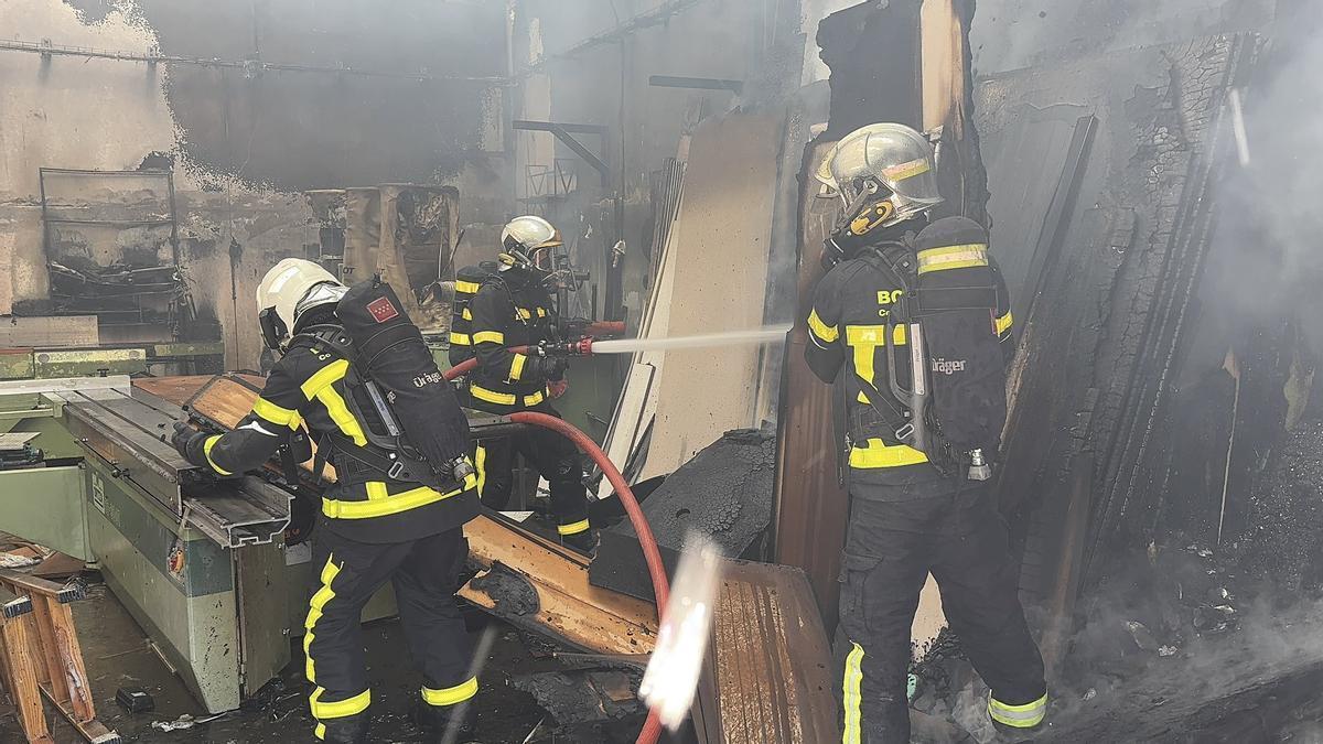 Varios bomberos de la Comunidad de Madrid tratan de apagar un incendio.
