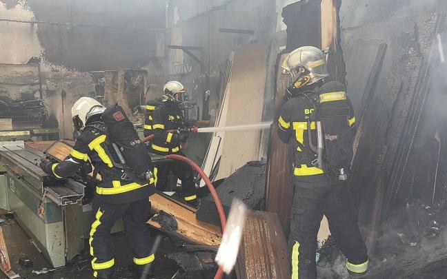 Varios bomberos de la Comunidad de Madrid tratan de apagar un incendio.