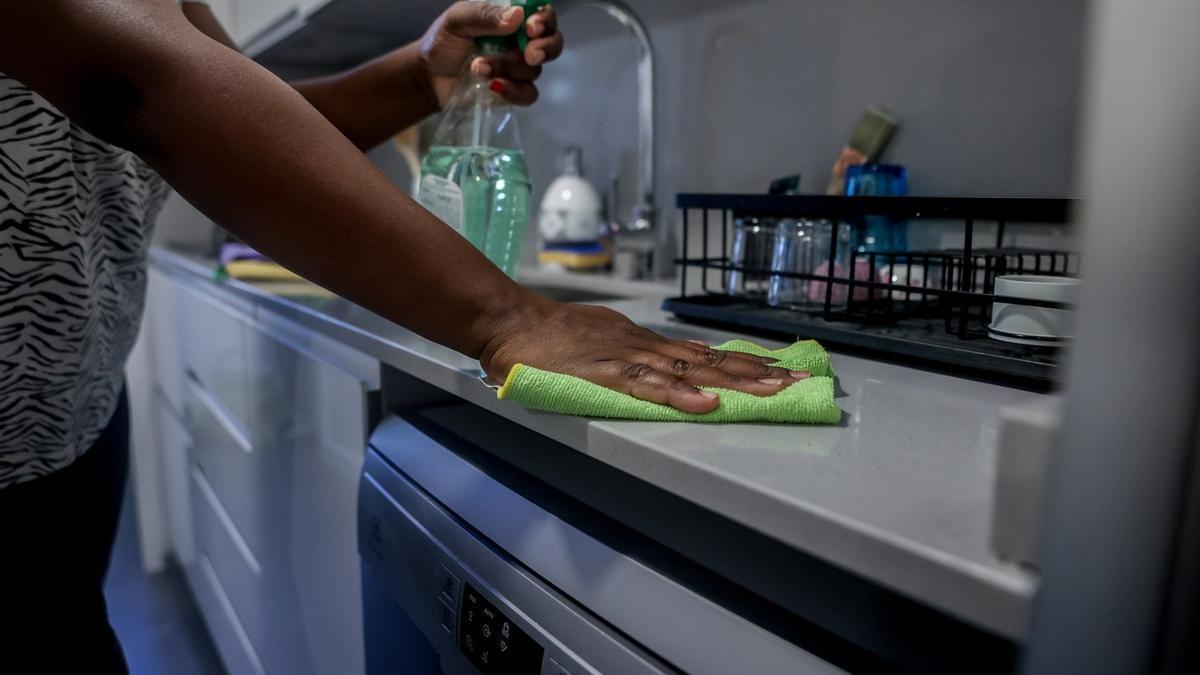 Una empleada de hogar limpia la encimera de la cocina, en una imagen de archivo