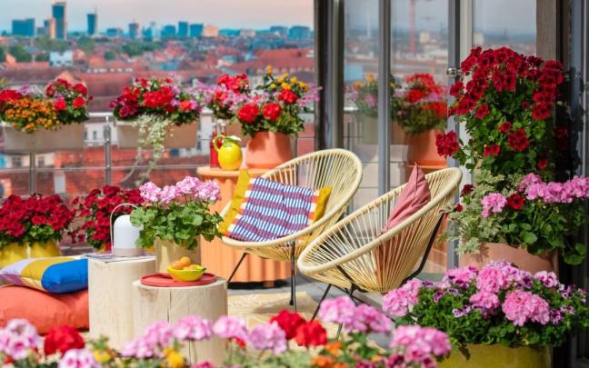 Ático con una terraza llena de flores en plena ciudad.