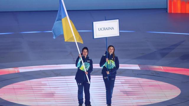 Una deportista porta la bandera de Ucrania en la ceremonia de apertura de los Juegos Paralímpicos de Milán-Cortina