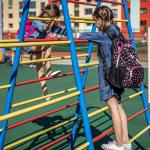Dos niñas jugando en el patio de un colegio.