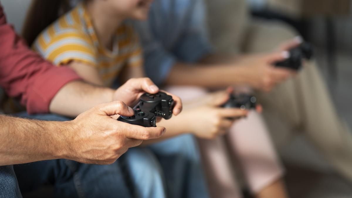 Varias personas se divierten con videojuegos.