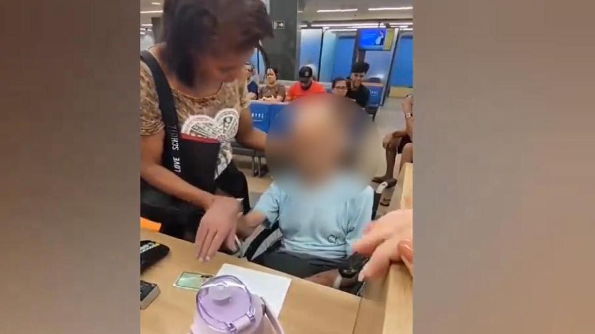 La mujer sujeta la cabeza del finado e intenta que firme el documento para que se le conceda el préstamo.