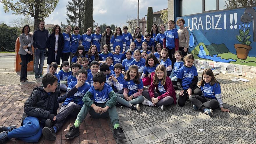 Los escolares de Aresketa Ikastola junto al mural sobre el ciclo del agua que han pintado en la sede de Urbide en Amurrio