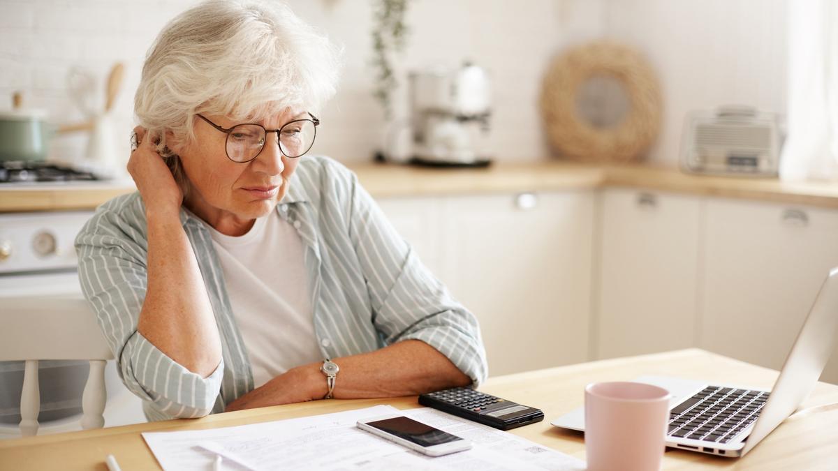 Una mujer jubilada realiza cuentas de sus finanzas personales.