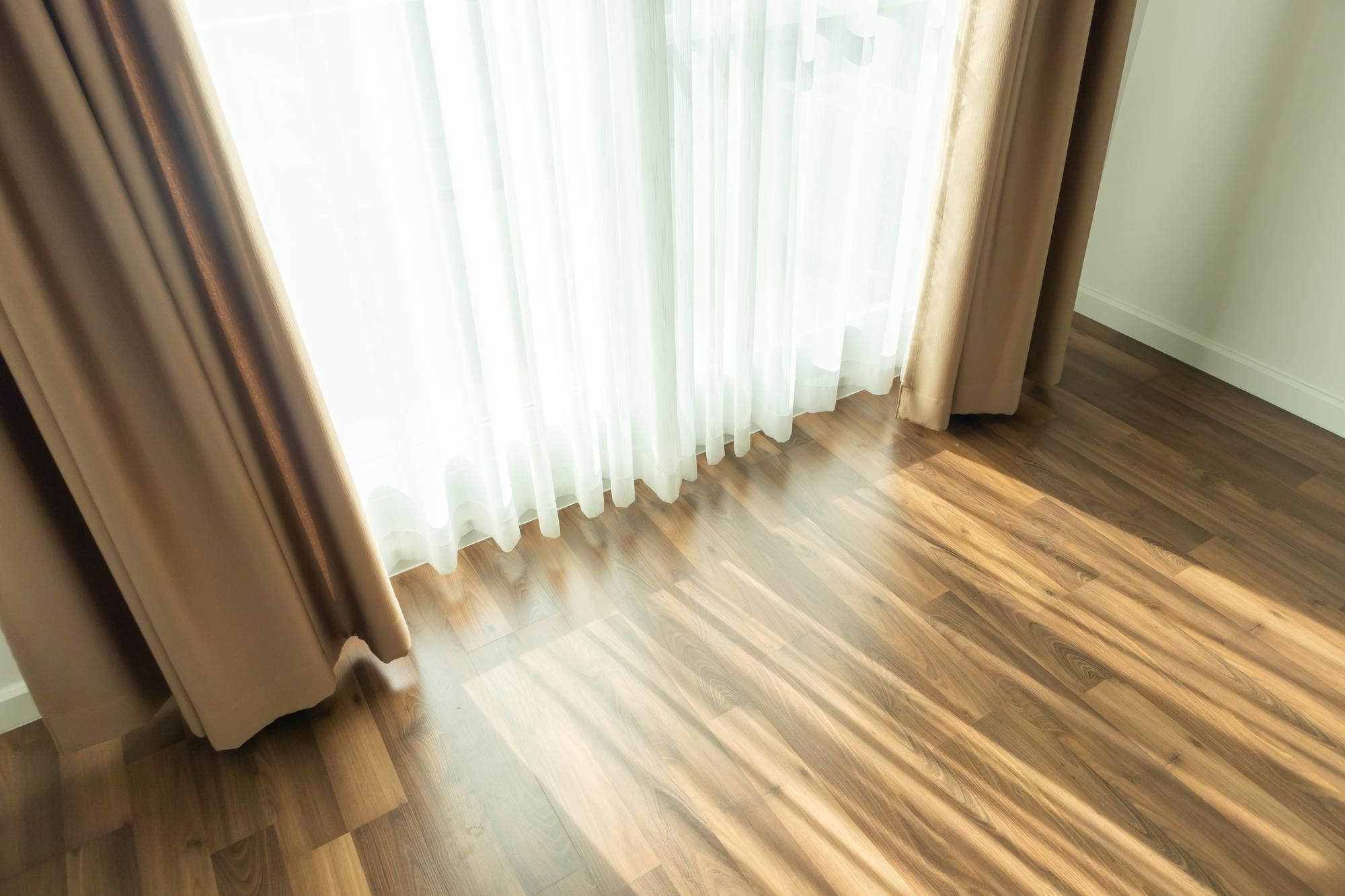 Doble cortina en el ventanal de una habitación muy soleada.