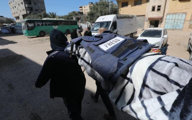 Traslado del cuerpo de la periodista asesinada, bajo su escudo antibalas.