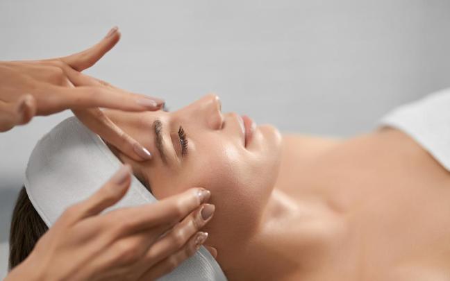 Una mujer se aplica un tratamiento estético facial.