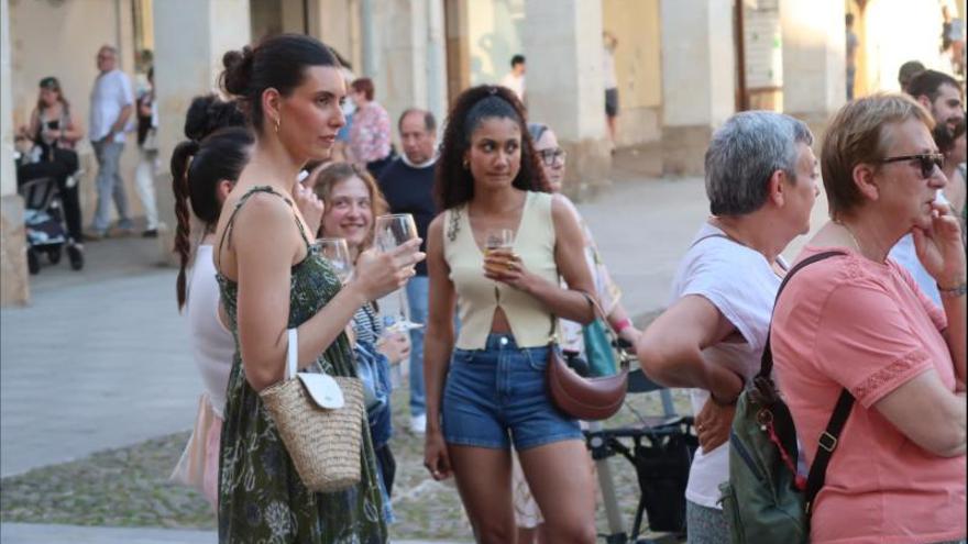 Unas jóvenes disfrutan del concierto y del pintxo-pote.