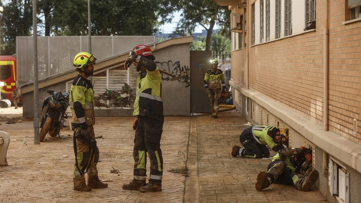 Varios bomberos buscando en los garajes afectados