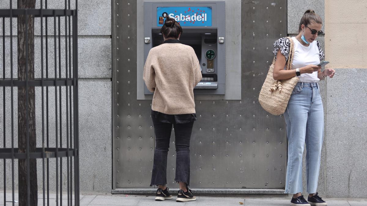 Dos mujeres, ante un cajero automático.