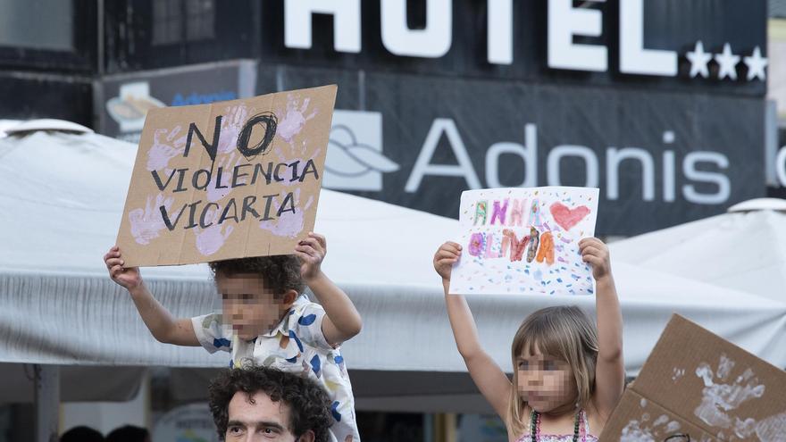 Dos niños con carteles, participan en una concentración feminista.