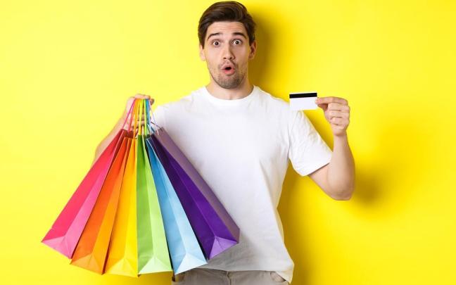 Un hombre realiza compras con su tarjeta de crédito. Un hombre realiza compras con su tarjeta de crédito.