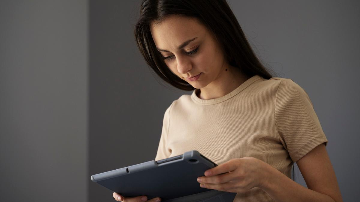 Mujer sosteniendo un dispositivo electrónico.