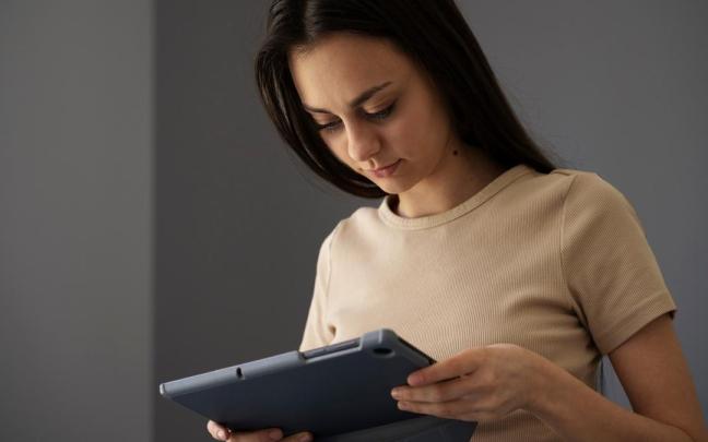 Mujer sosteniendo un dispositivo electrónico.