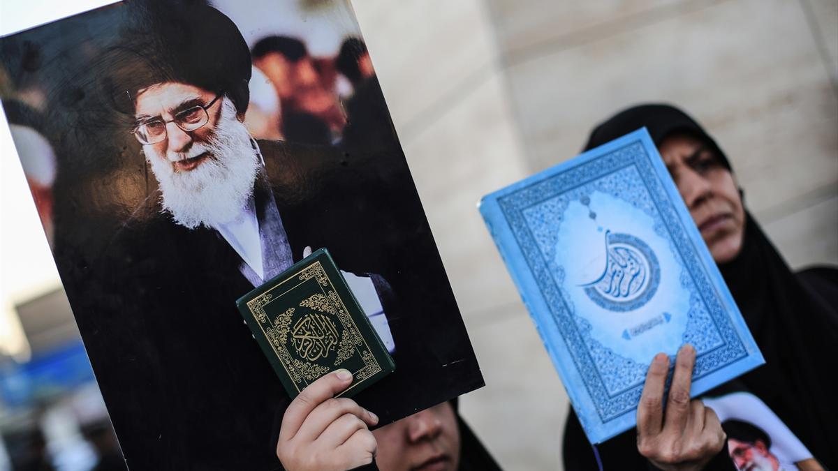 Dos mujeres en Irak sostienen sendas copias del Corán y una imagen del líder supremo de Irán, Ali Jameneí.