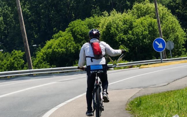Imagen del ciclista paseando a un loro en plena carretera