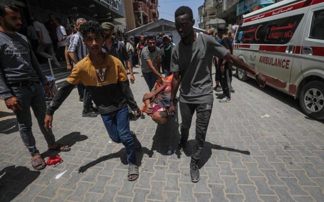 Palestinos trasladan a un herido en un ataque israelí para liberar a cuatro rehenes