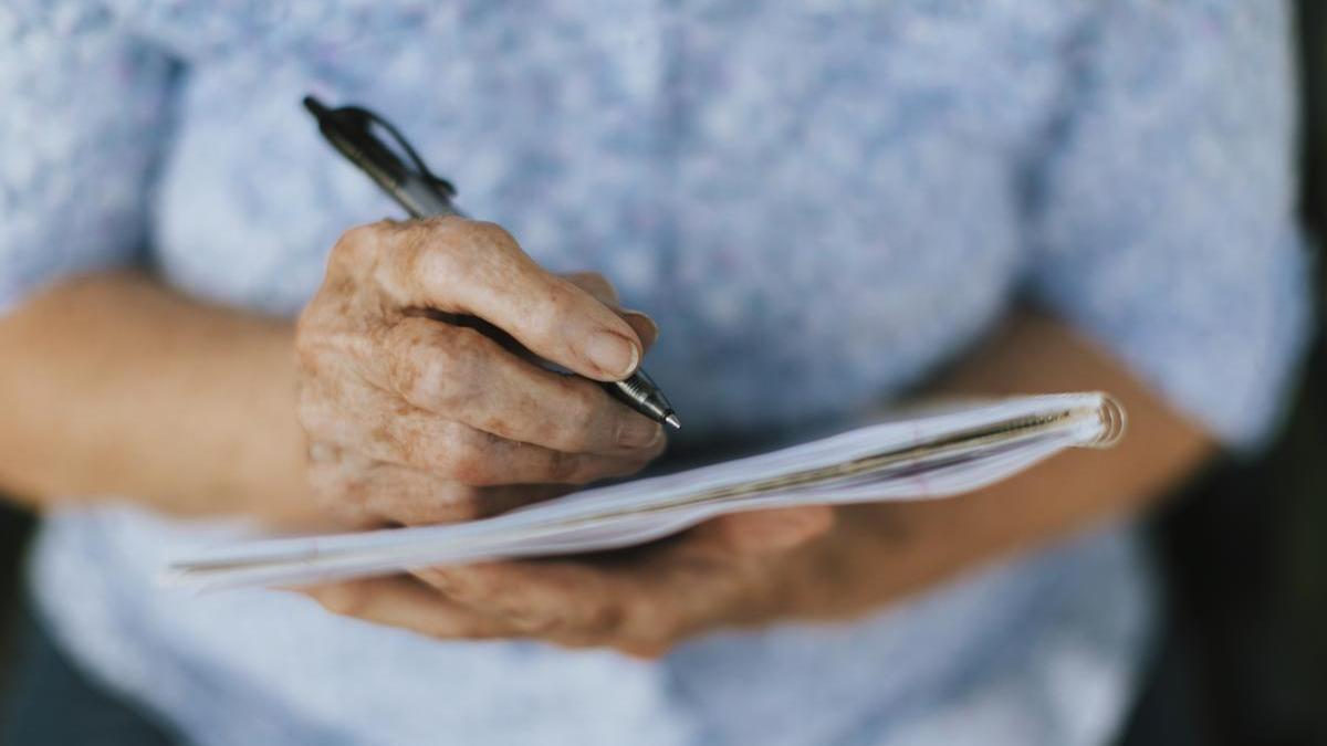 Mujer anota en una libreta.