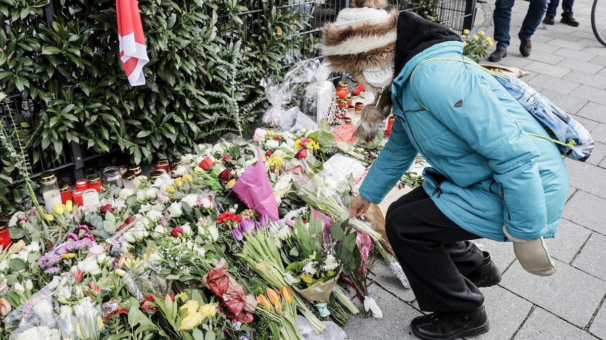 Una mujer deposita flores en el lugar donde ocurrió el atropello