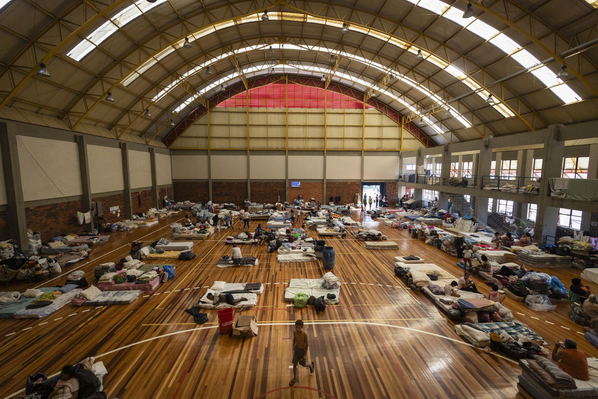Personas afectadas por las inundaciones se resguardan en un albergue en un polideportivo de Porto Alegre.