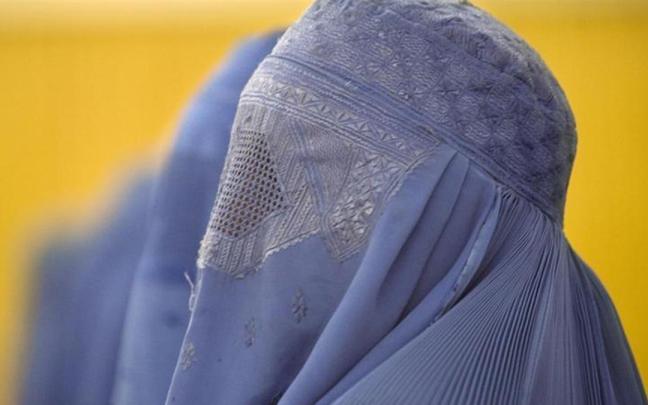 Una mujer se cubre el rostro con un burka.