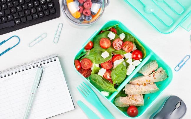 Tupper con ensalada sobre el escritorio de una oficina.