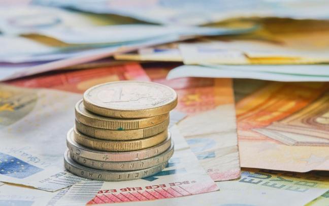 Monedas y billetes de euro de distinto valor extendidos.