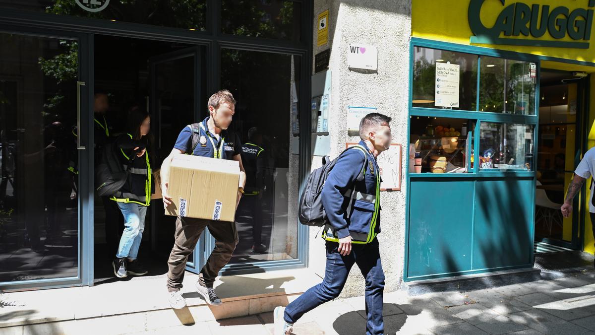 Agentes de la Policía Nacional salen de las oficinas de la empresa What The Fav, perteneciente a las hijas de Zapatero,.