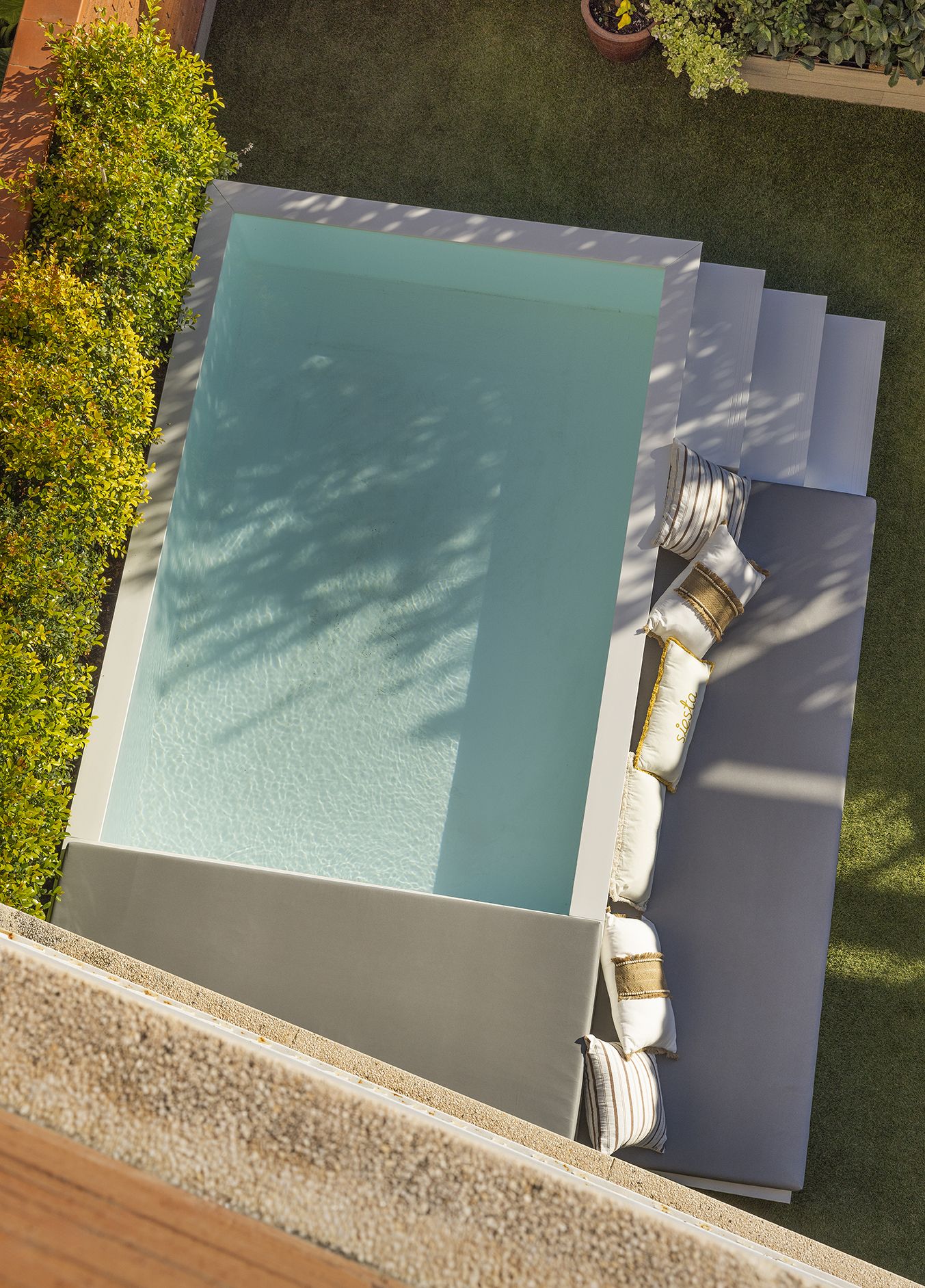 Vista aérea de la piscina con la escalinata y el banco.