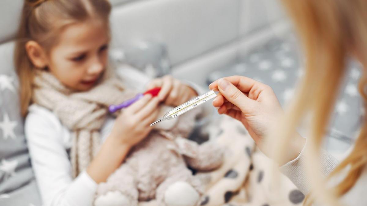 Madre toma la fiebre a su hija