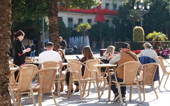 Una camarera atendiendo la terraza de un bar