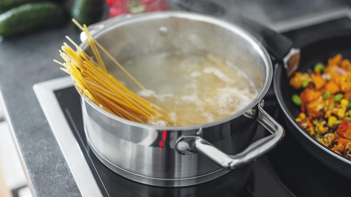 Una olla con agua en el fuego para cocer espaguetis.