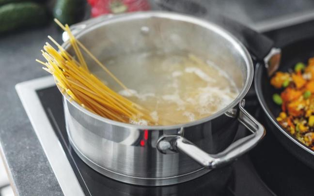 Una olla con agua en el fuego para cocer espaguetis.