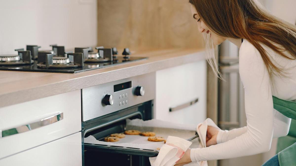 Chica prepara unas deliciosas galletas caseras en el horno